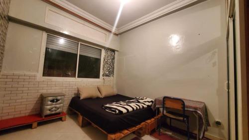 a small room with a bed and a window at SK Homestay in Casablanca