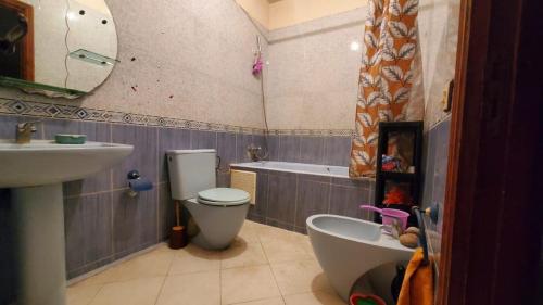 a bathroom with a sink and a toilet and a bath tub at SK Homestay in Casablanca
