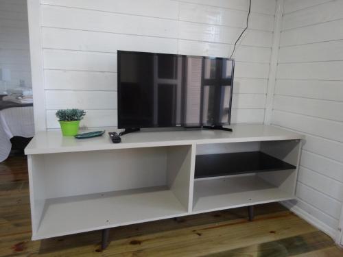 a white entertainment center with a flat screen tv at Pousada Rancho do Lago in Osório