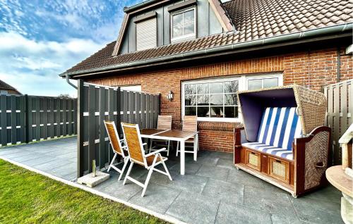 a patio with a table and chairs and a fence at Ferienhaus Trischenblick in Friedrichskoog
