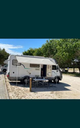 a white caravan parked in a parking lot at Hymer CamperVan in Lisbon
