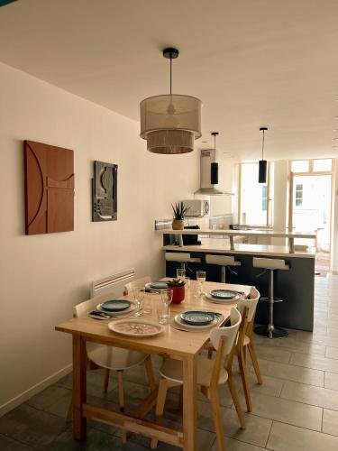 une cuisine avec une table en bois et des chaises ainsi qu'une salle à manger dans l'établissement Wine House - Maison de Ville Chablis centre, à Chablis
