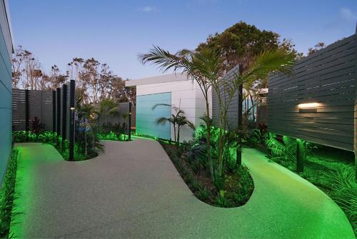 a walkway with green plants and a building at Cavvanbah - Gypsy Villa in Byron Bay