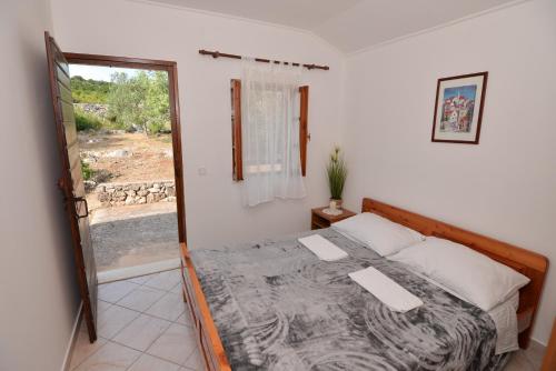 a bedroom with a bed and a sliding glass door at Secluded fisherman's cottage Cove Zizanj, Pasman - 23925 in Tkon