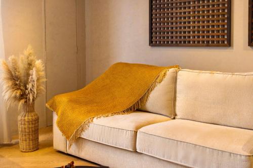 a white couch with a yellow blanket on it at ❈ Tropicana 218 by ALV Suites ❈ in George Town