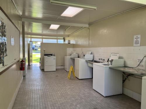 a laundry room with washers and dryers in it at Young Caravan and Tourist Park in Young