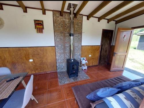 a living room with a wood stove in a room at Cabaña privada con acceso a playa in Quilquico