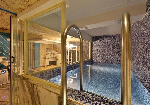 a large swimming pool in a room with a glass door at February Hotel Gimhae in Gimhae