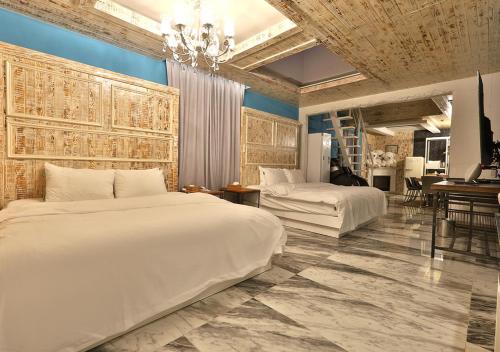 a bedroom with two beds and a chandelier at February Hotel Gimhae in Gimhae