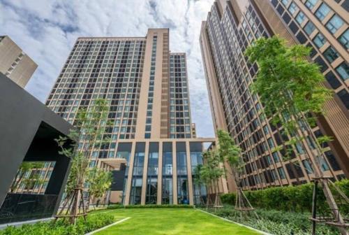 a tall building with a lawn in front of it at Luxury condo in Bangkok,NearBTSMochit,MRTChatuchak in Bangkok
