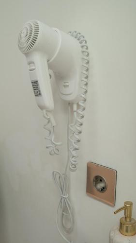 a white hairdryer and a hair dryer on a wall at Pagi Villas by Betterplace in Canggu