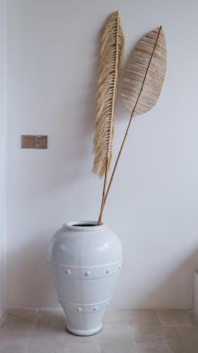 a white vase with a feather sticking out of it at Pagi Villas by Betterplace in Canggu