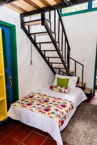 a bed sitting in a room with a staircase at Hotel campestre La Esperanza en Dios in Montenegro