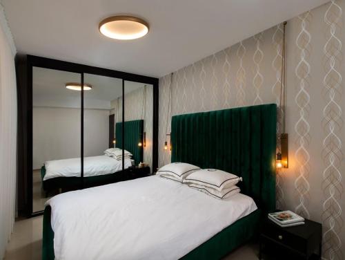 a bedroom with a large white bed and a mirror at Lovely 3 Bedroom Mini Penthouse on 30th Floor in Netanya