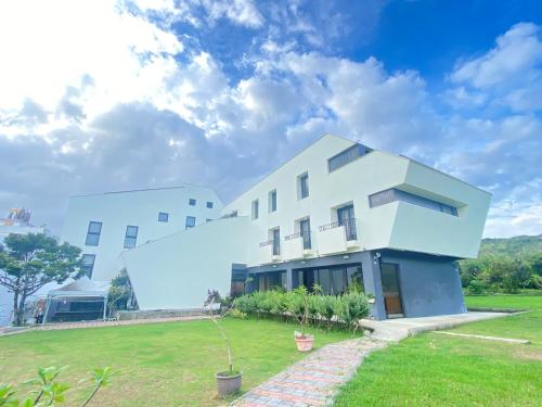 a large white building with a grass yard at Wangan 175 B&B in Shui-wa-chüeh