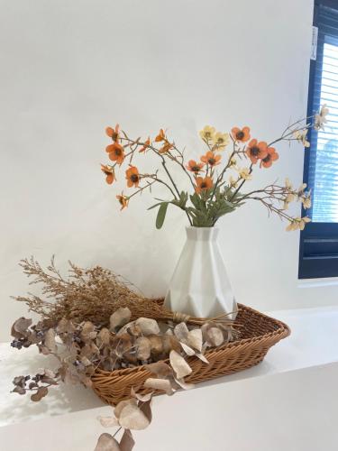 a white vase with some flowers in a basket at Wangan 175 B&B in Shui-wa-chüeh