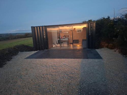 a small house with a large window and a table at The 9 acre in Midleton