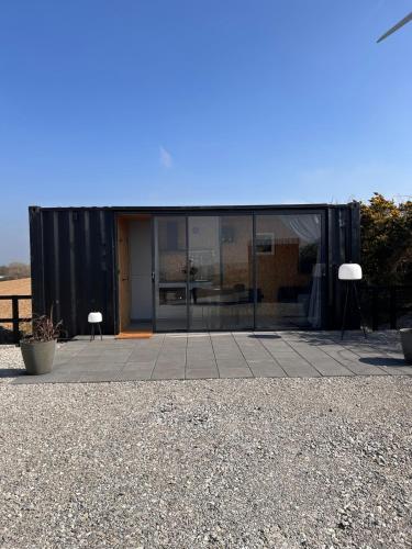 a black building with two chairs and a table at The 9 acre in Midleton
