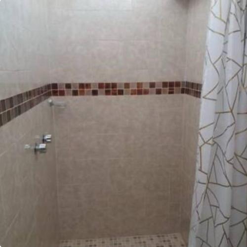 a shower with a glass door in a bathroom at MI CASA EN TEPOZTLAn in Tepoztlán