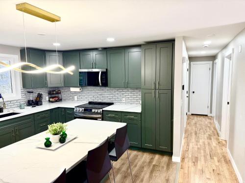 a kitchen with green cabinets and a table with chairs at Cosy Retreat at Auburn near Muckleshoot in Auburn