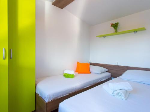 two beds in a room with green and white at Zelena Laguna Mobile Homes in Poreč