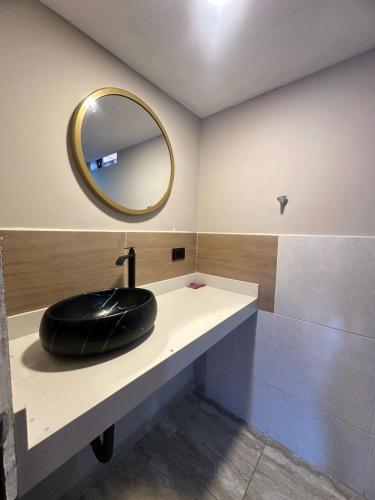 Un baño con un lavabo negro y un espejo. en Hotel Coral Boutique, en Medellín
