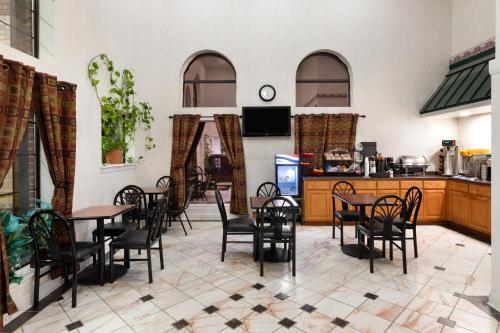 un ristorante con tavoli, sedie e un bancone di Ramada Limited San Angelo a San Angelo