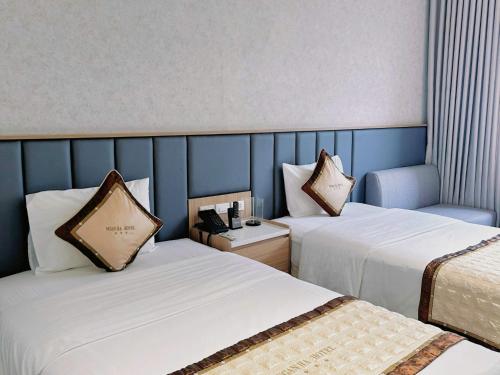 a hotel room with two beds and a blue wall at NGAN HA HOTEL in Ðại Tiêt
