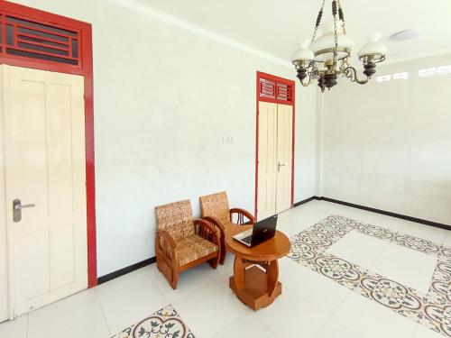a room with a door and a table and chairs at RedDoorz near Alun-Alun Purwokerto 3 in Purwokerto