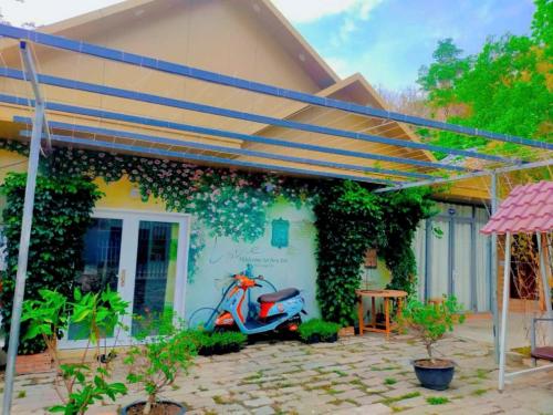 a scooter parked under a pergola next to a house at Huy Hoàng Homestay Kiên Giang in Lai Sơn