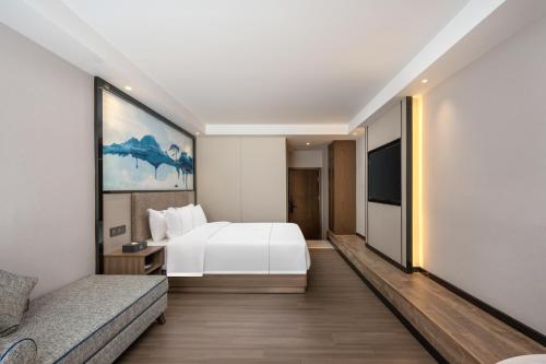 a hotel room with a bed and a tv at 汉诺酒店-Canton Fair Free Shuttle Bus in Guangzhou