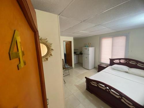 a bedroom with a large bed and a kitchen at casa MH - rodadero in Gaira