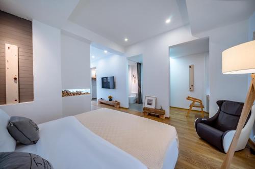 a bedroom with a large bed and a chair at Dali Kong Xiang Weiwenshan Craft hotel in Dali