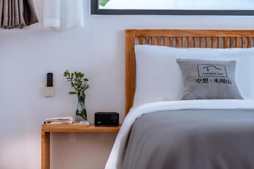 a bedroom with a bed and a table with a pillow at Dali Kong Xiang Weiwenshan Craft hotel in Dali