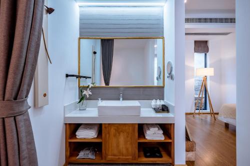 a bathroom with a sink and a mirror at Dali Kong Xiang Weiwenshan Craft hotel in Dali
