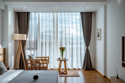 a bedroom with a bed and a table and a window at Dali Kong Xiang Weiwenshan Craft hotel in Dali