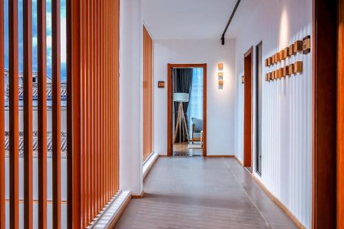 a hallway with orange and white walls and doors at Dali Kong Xiang Weiwenshan Craft hotel in Dali