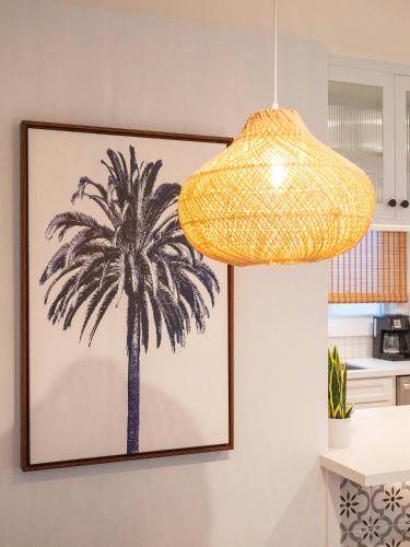a picture of a palm tree on a wall with a lamp at Surf Casita - Luxury Beach Home - Steps to Ocean & Walk to everything in Newport Beach
