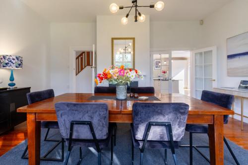 a dining room with a wooden table and chairs at Grand 5-Bedroom Villa in Fendalton in Christchurch