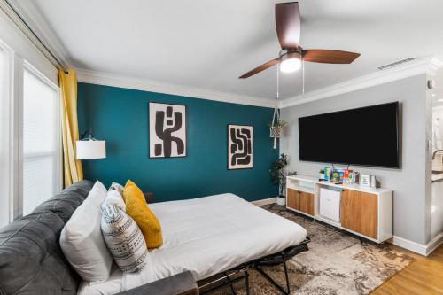 a living room with a couch and a flat screen tv at Rare Exclusive Retreat Private Hot Tub King Bed in Saskatoon
