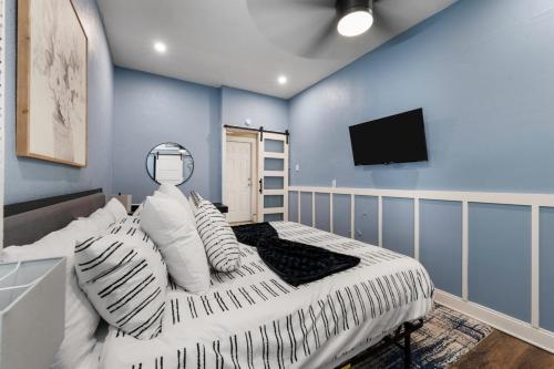 a bedroom with blue walls and a bed with white pillows at Rare Exclusive Retreat Private Hot Tub King Bed in Saskatoon