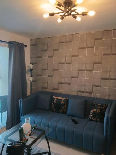 a living room with a blue couch and a table at Cómodo Apartamento en Santiago in Santiago de los Caballeros