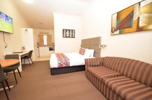 una habitación de hotel con una cama y un sofá en Boulevarde Motor Inn, en Wagga Wagga