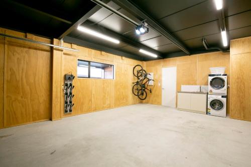 a garage with a washer and dryer and a washing machine at Stunning & modern home with fantastic lake views in Queenstown