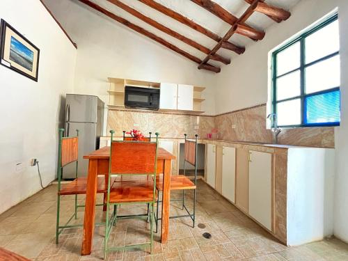 a kitchen with a table and chairs and a refrigerator at Posada Luisa Del Valle Guacuco in Playa Guacuco