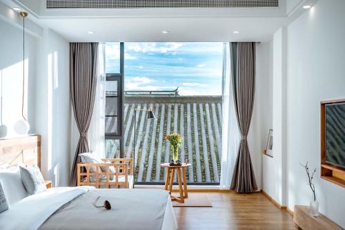 a bedroom with a bed and a large window at Dali Kong Xiang Weiwenshan Craft hotel in Dali