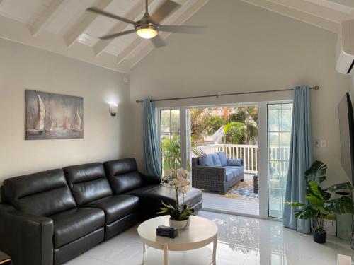 a living room with a black leather couch and a table at Marriott Apartment at Little Bay Country Club in Negril