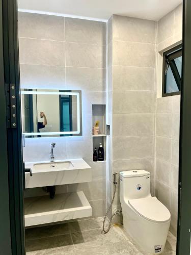 a bathroom with a toilet and a sink and a mirror at Luan Hoa Homestay in Ấp Bình Hưng