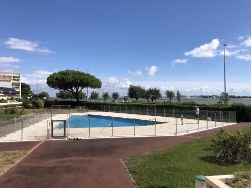 une piscine entourée d'une clôture dans l'établissement Appartement moderne avec terrasse et vue mer - La Rochelle - FR-1-535-47, à La Rochelle