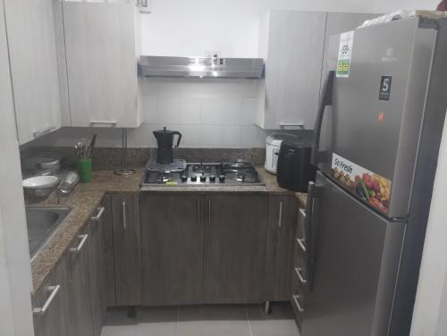 a kitchen with a stove and a refrigerator at Cómodo Apartamento en Santiago in Santiago de los Caballeros